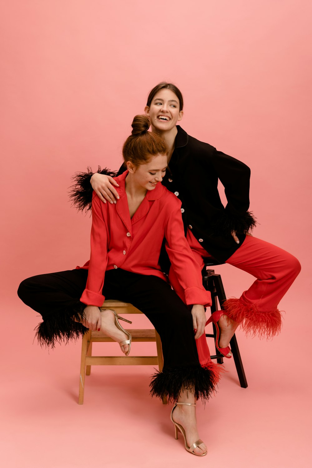 two women sitting on a chair posing for a picture