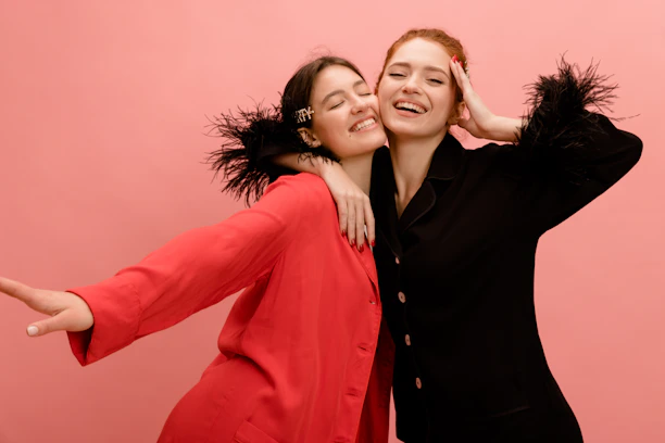 two women are hugging each other while posing for a picture