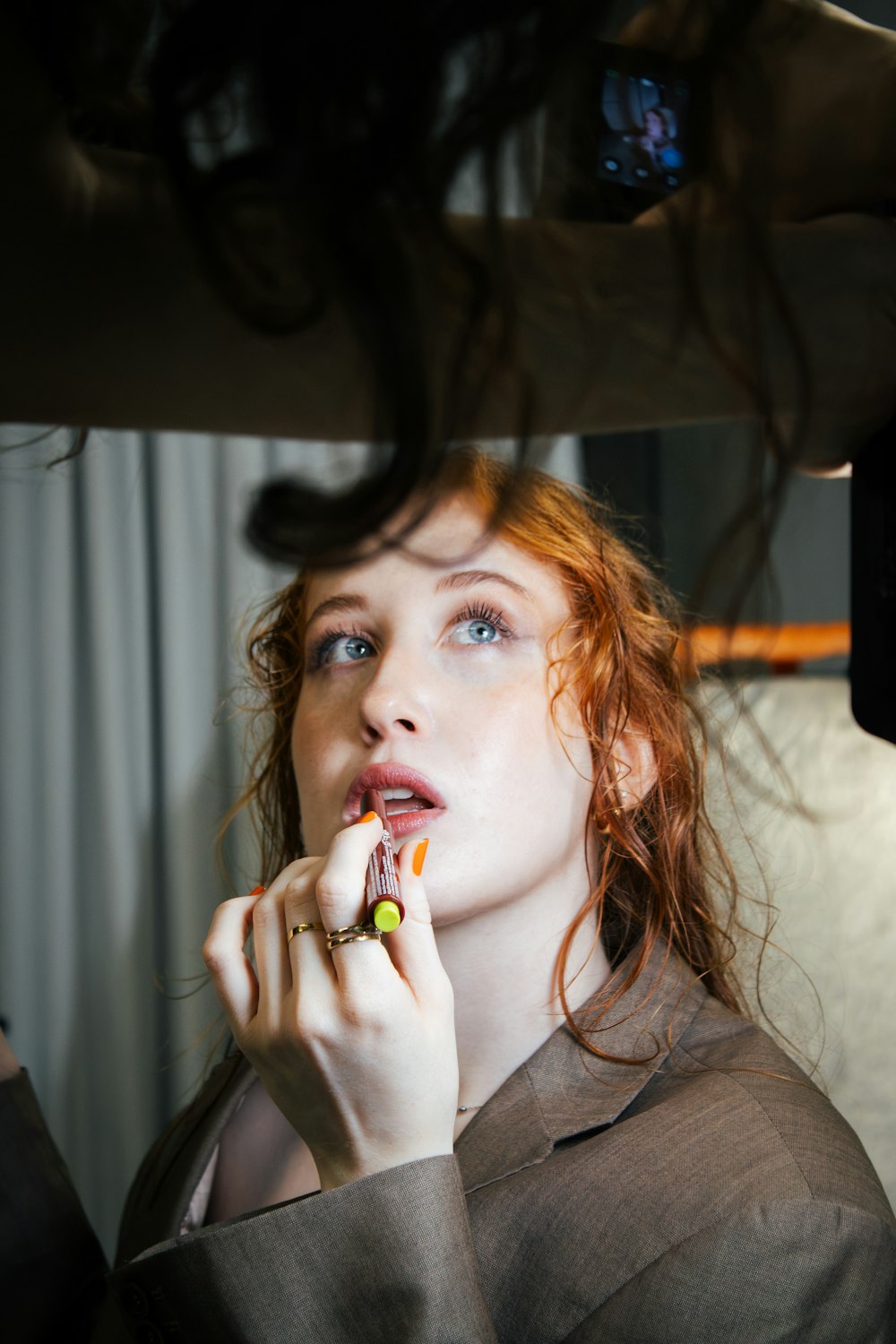 a woman with red hair brushing her teeth