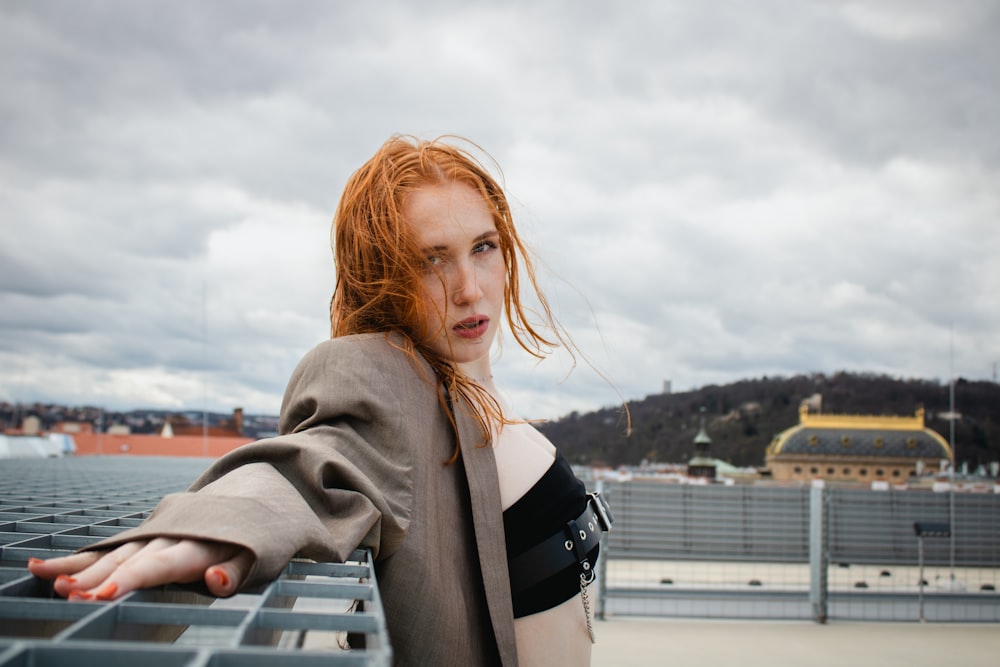 a woman with red hair is sitting on a bench