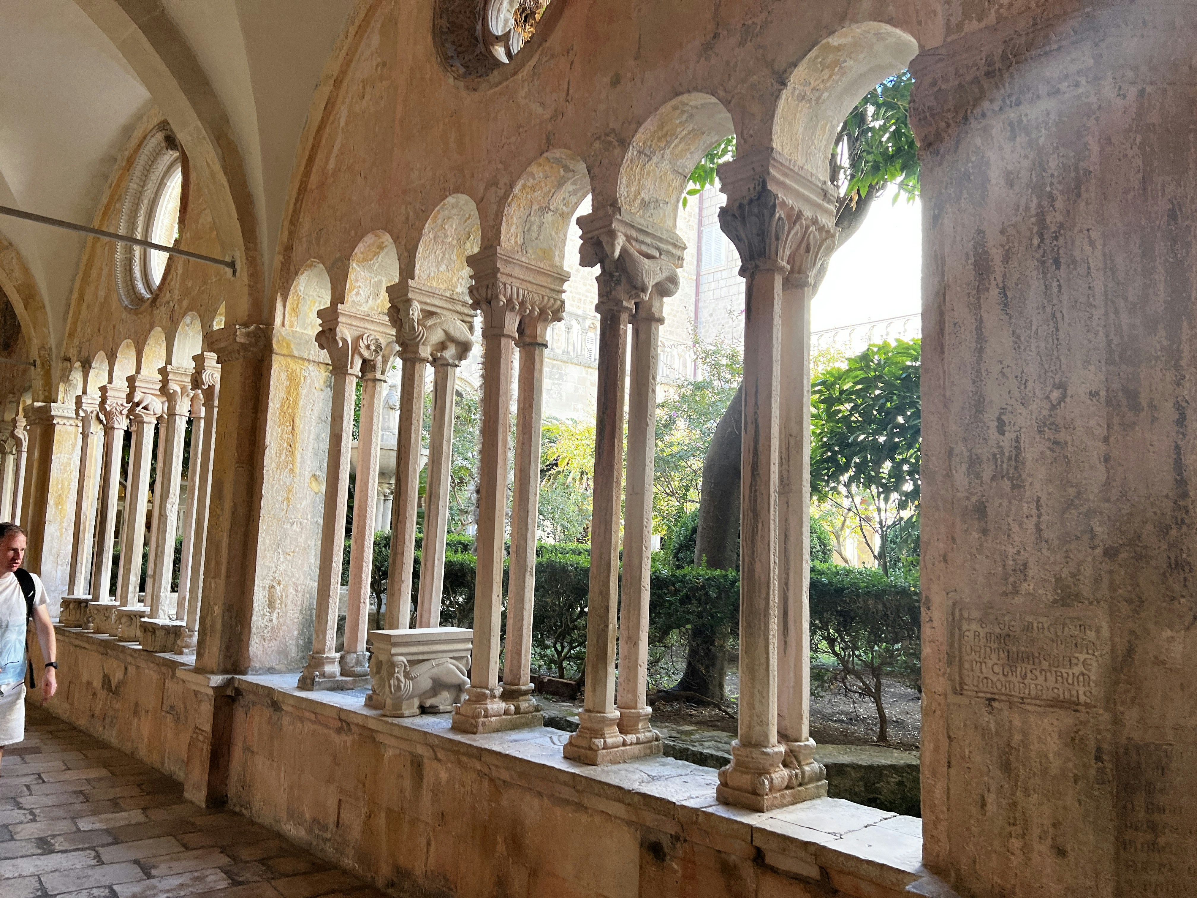 A woman is standing in a room with columns and arches