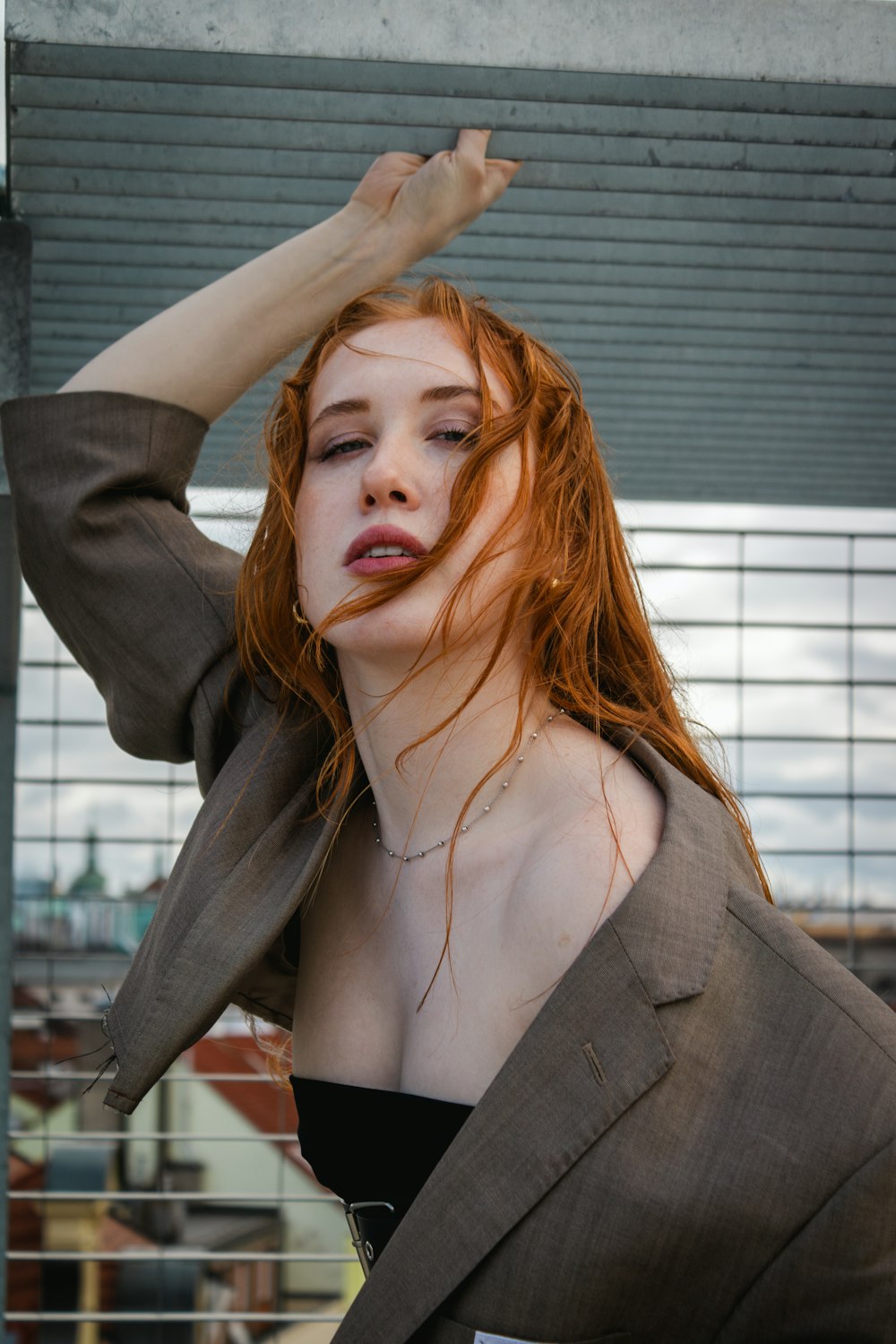 a woman with red hair wearing a suit