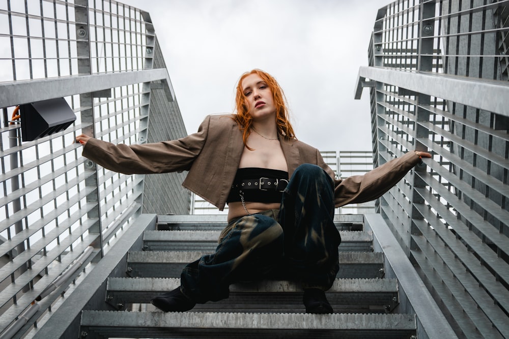 a woman with red hair sitting on a set of stairs