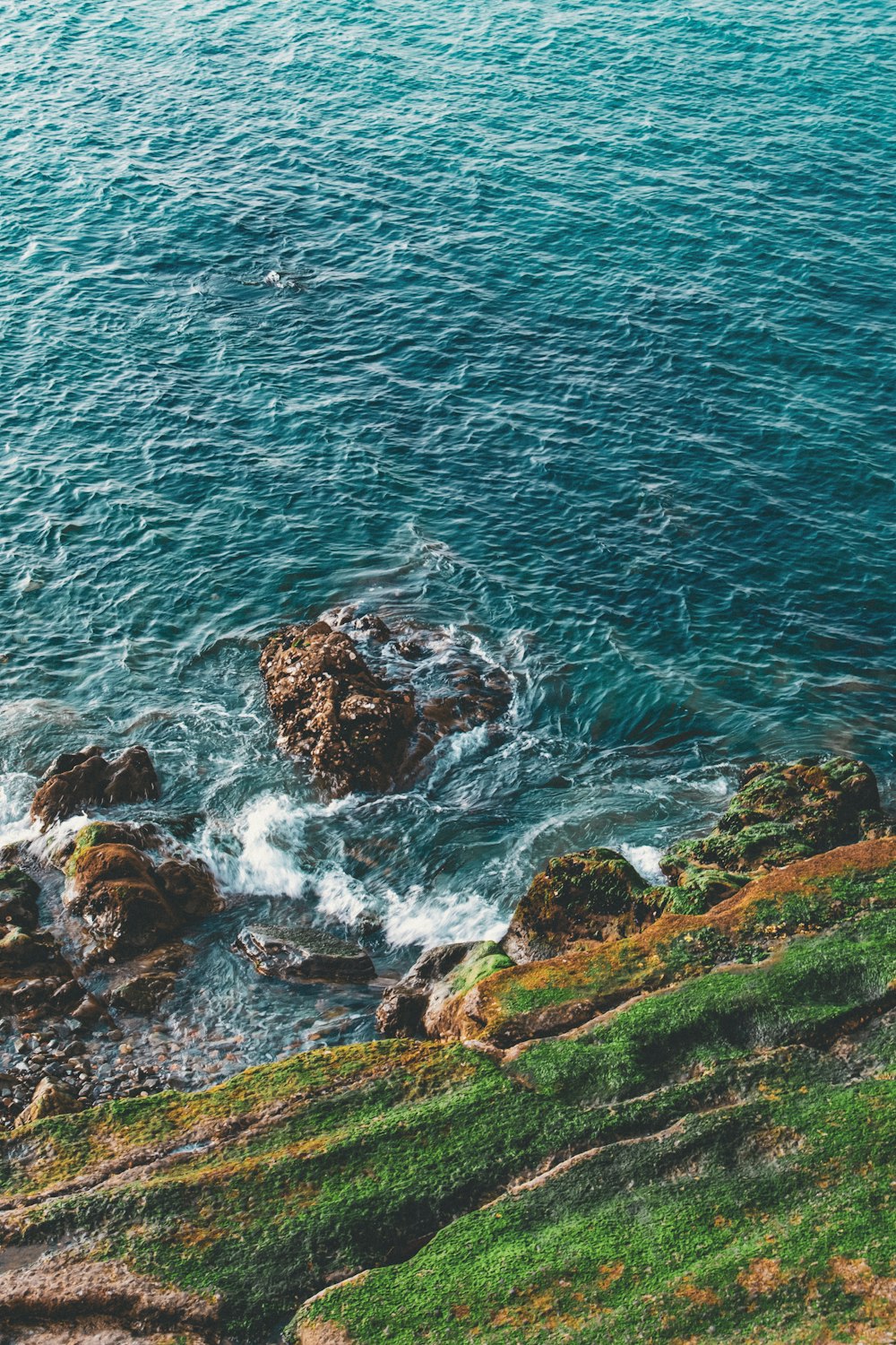 a couple of rocks sitting on top of a lush green hillside