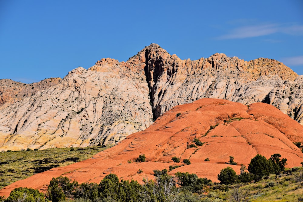 a mountain range with a large rock formation in the foreground