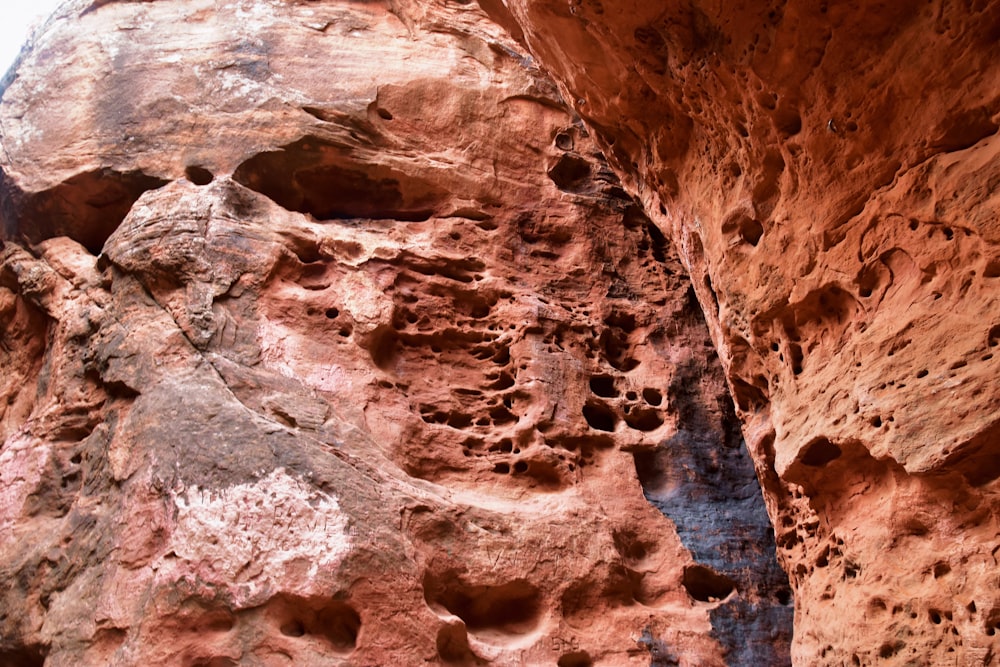 a rock formation with holes in the side of it