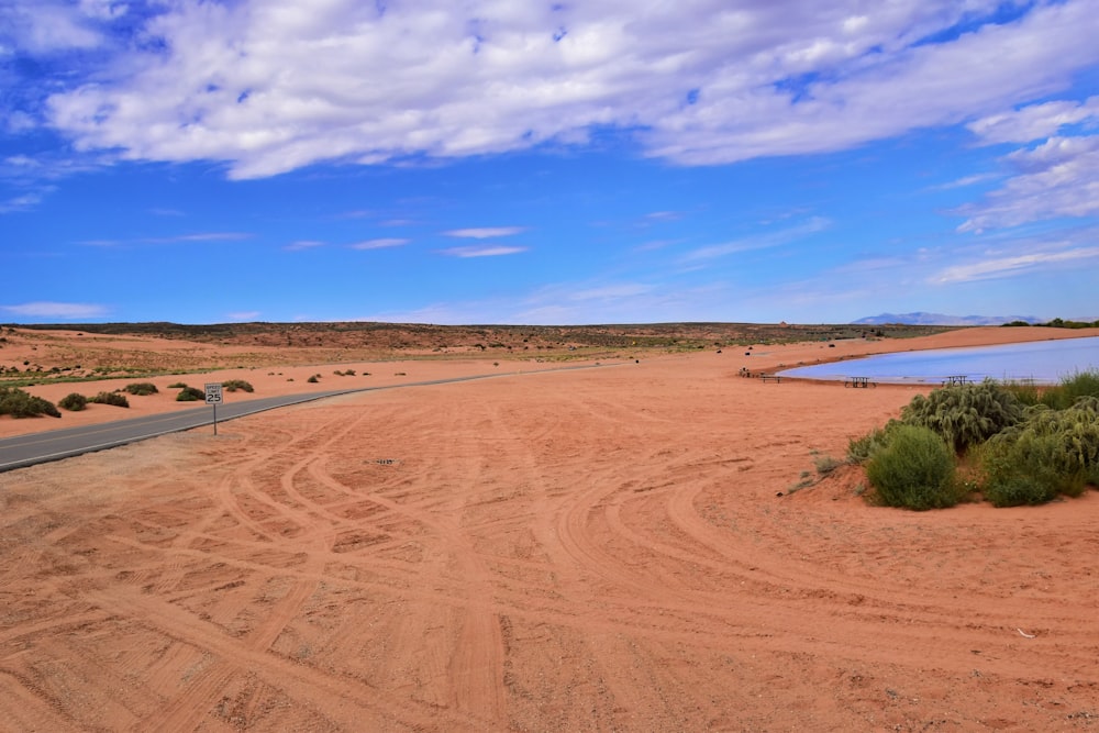 a dirt road with a body of water in the distance