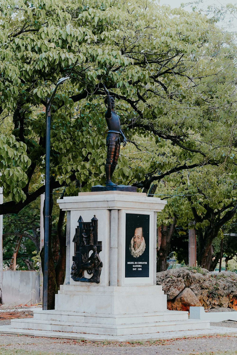 a statue of a woman is in the middle of a park