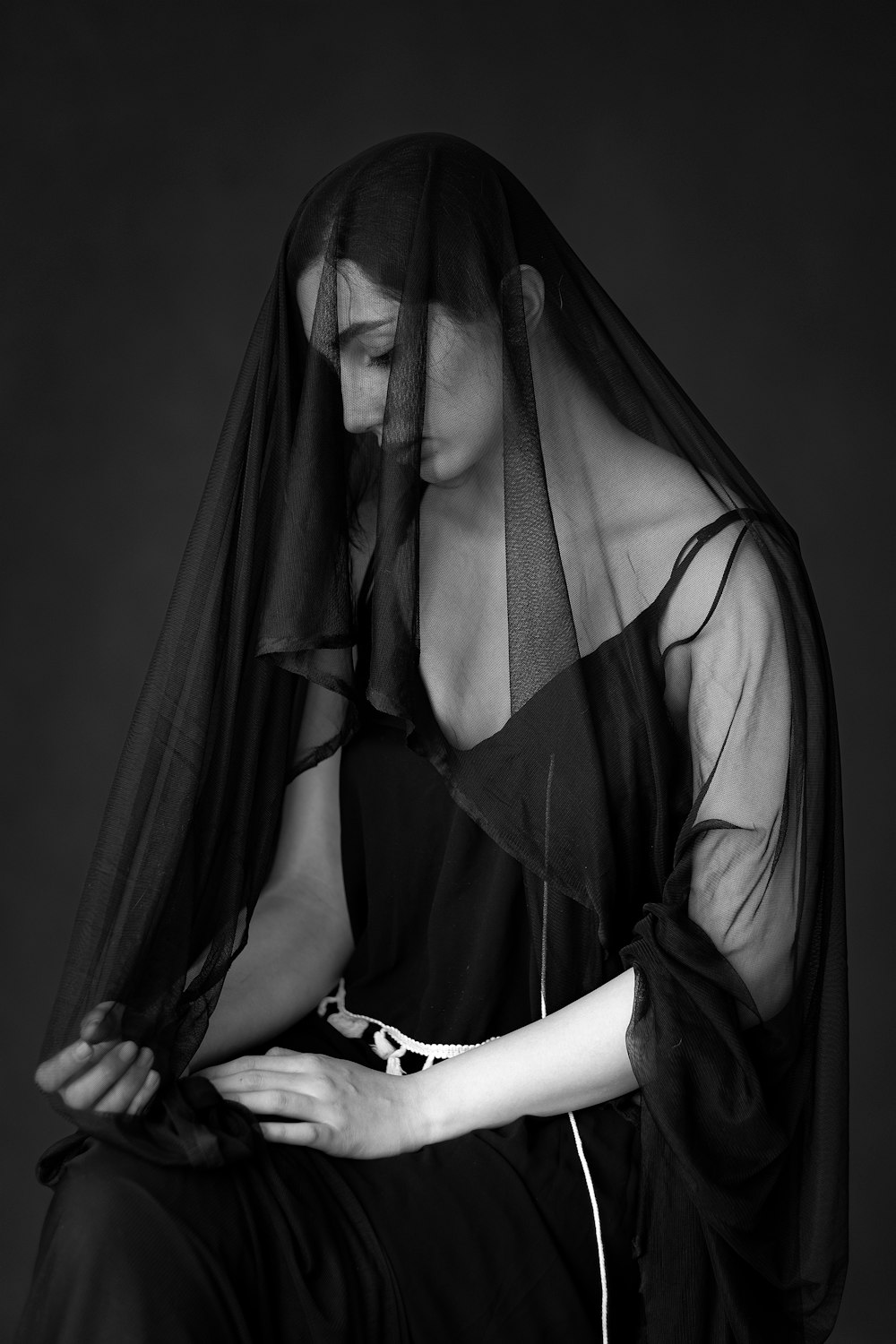 a black and white photo of a woman wearing a veil