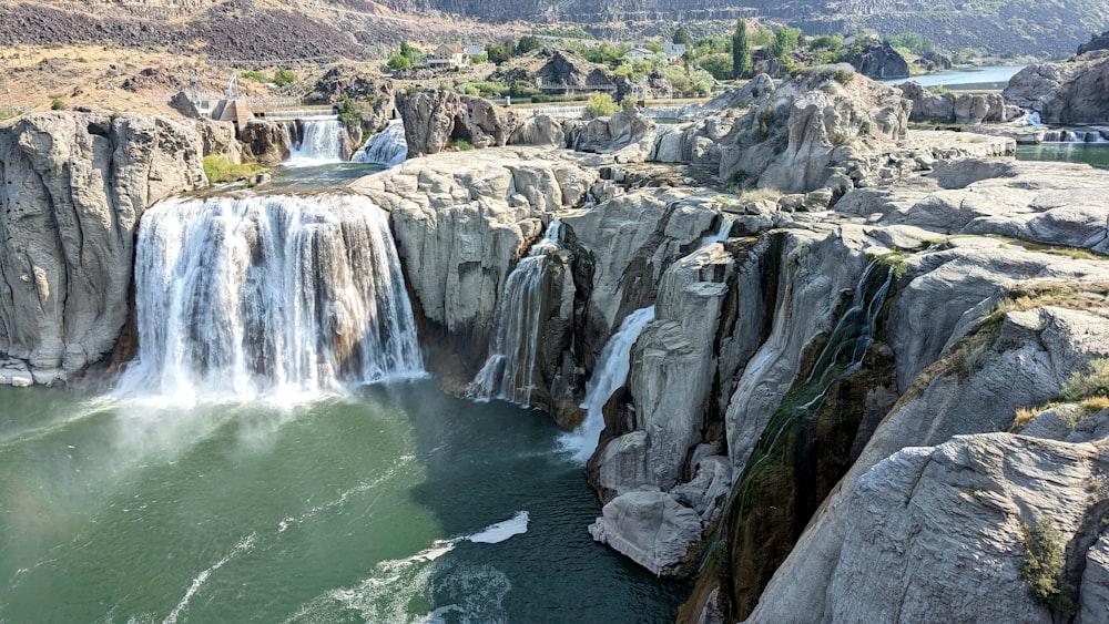 a large waterfall with a man standing on top of it