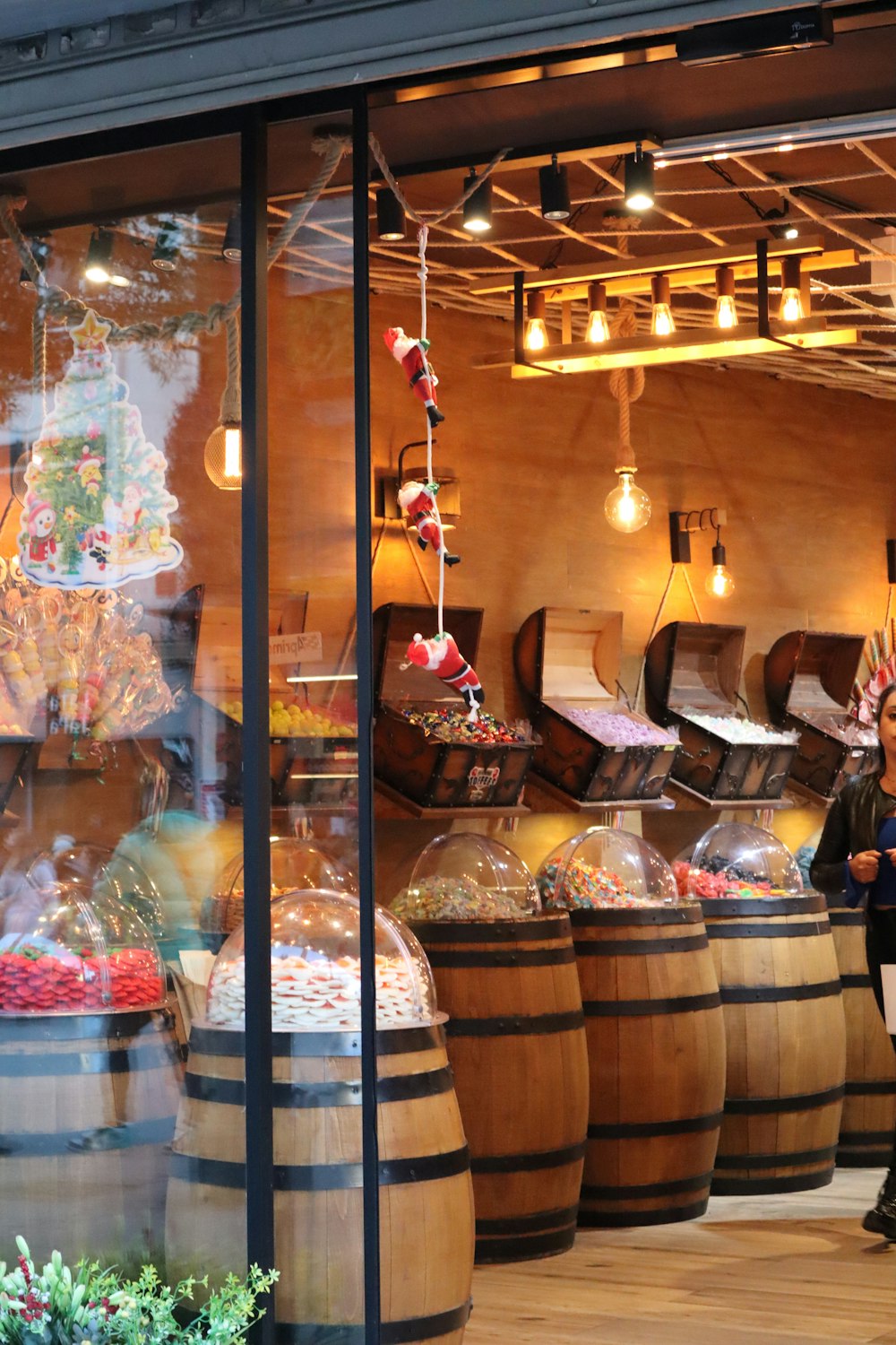 a man standing in front of a store filled with wooden barrels