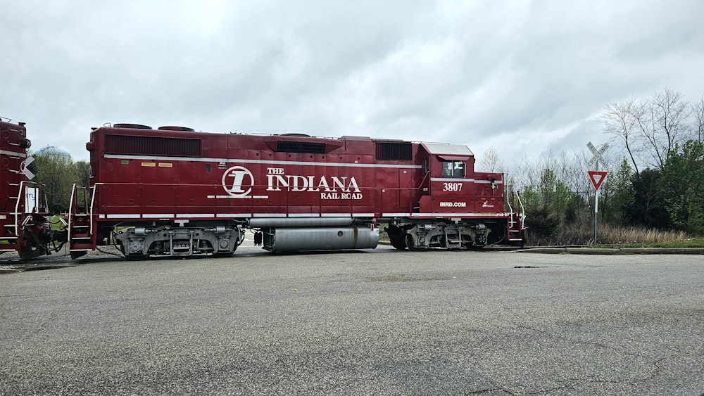 a red train car sitting in a parking lot