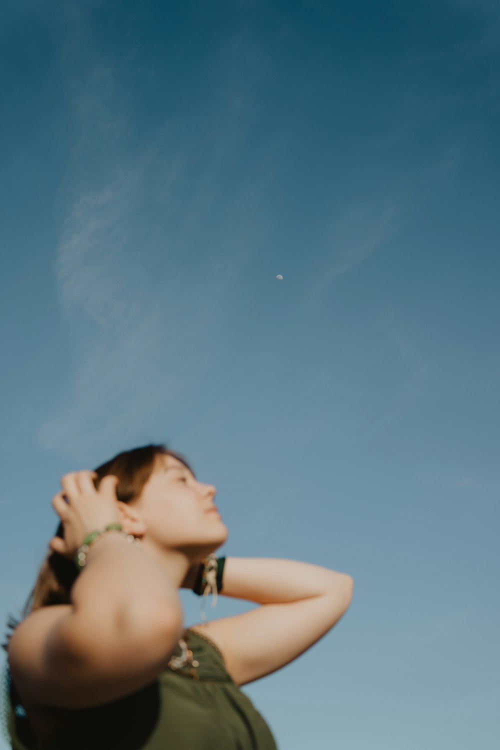 a woman in a green dress is flying a kite