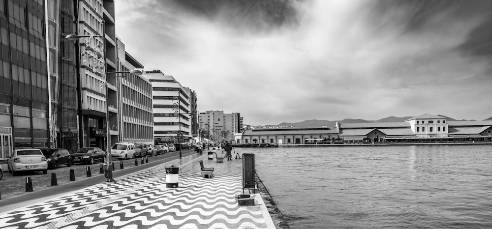 a black and white photo of a city next to a body of water