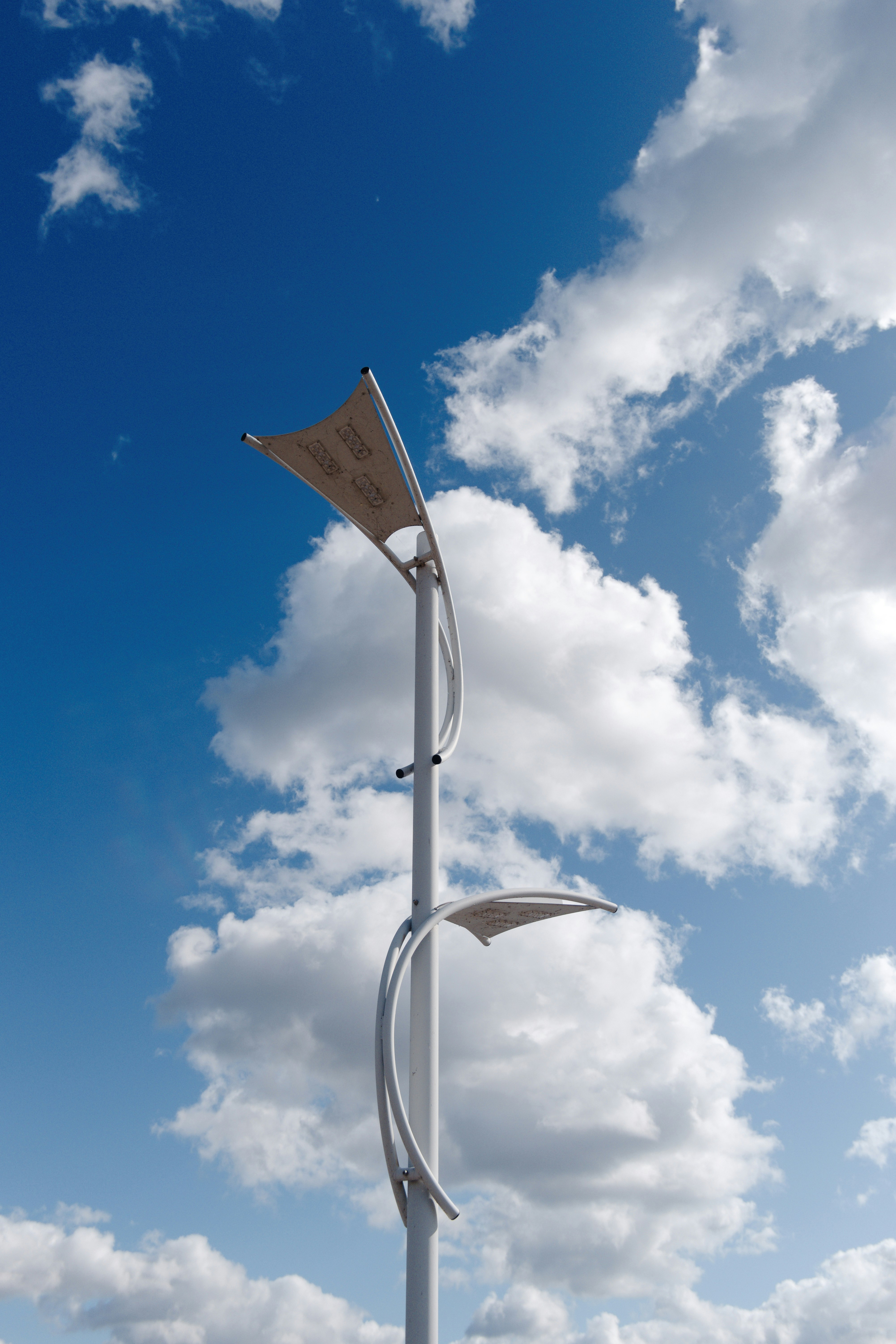 a tall white pole with two flags on top of it