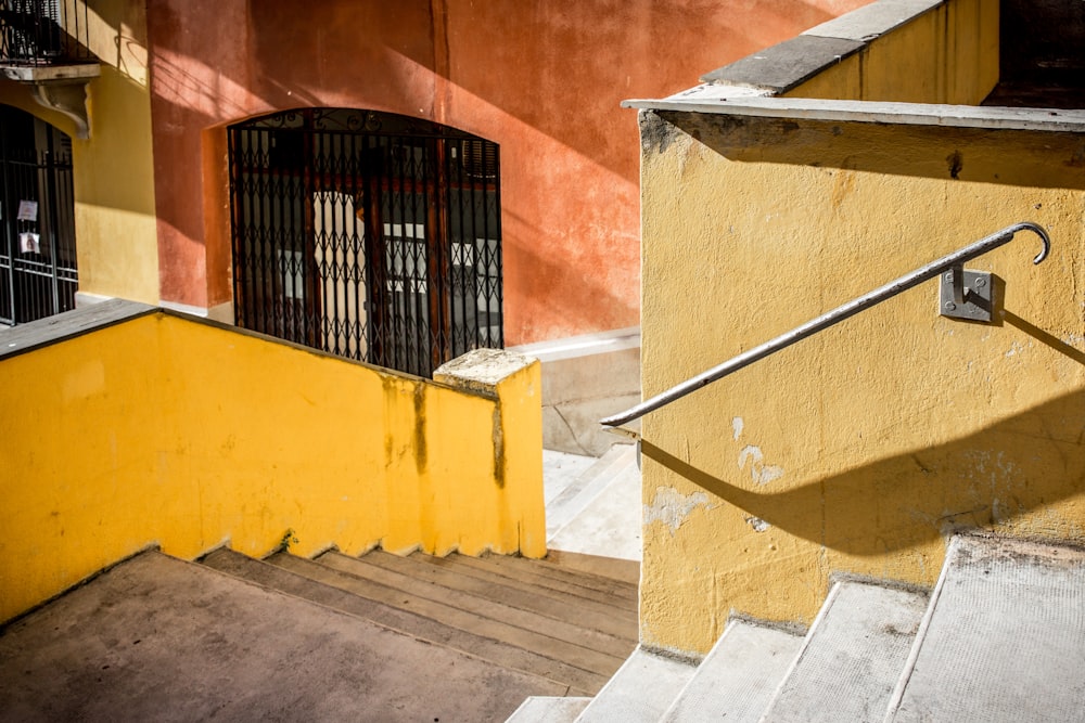 a stair case next to a yellow building