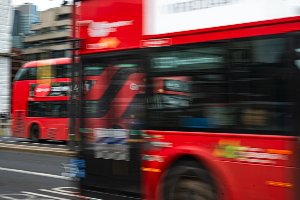 a red double decker bus driving down a street