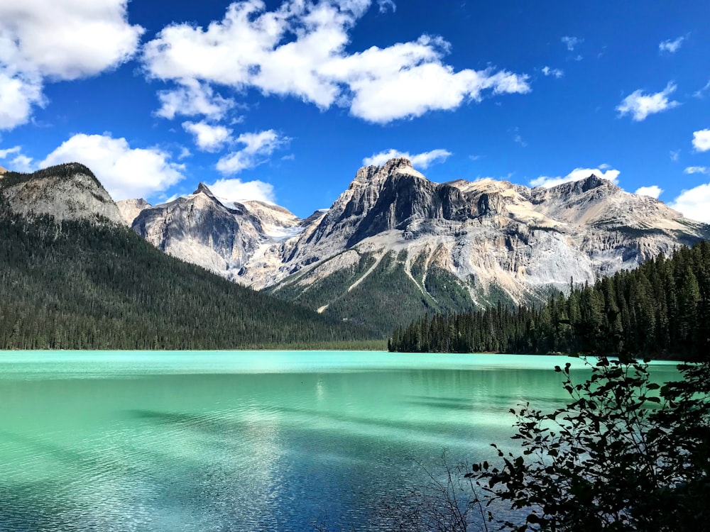 a lake surrounded by mountains under a blue sky