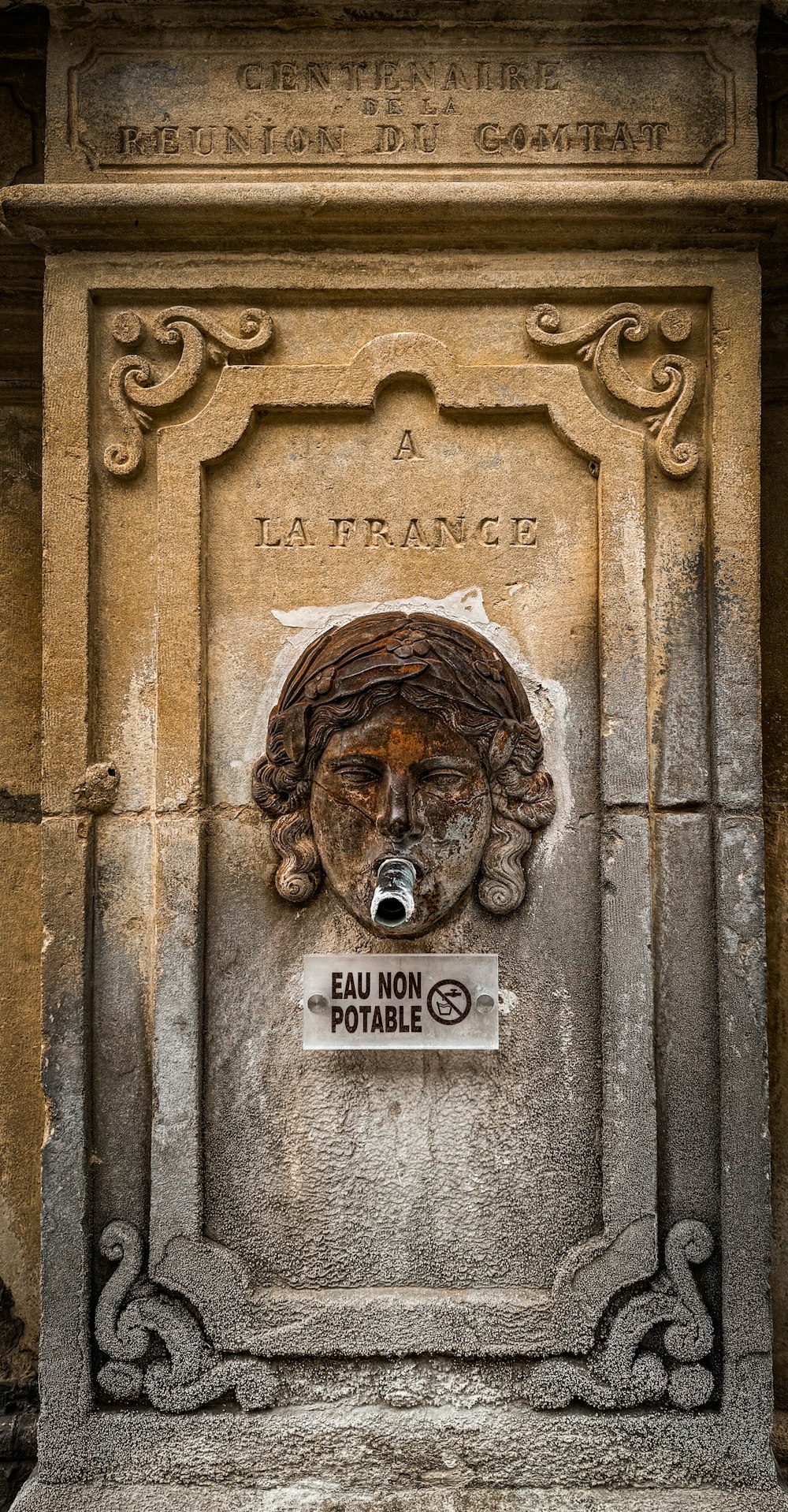 a statue of a dog with a sign in front of it