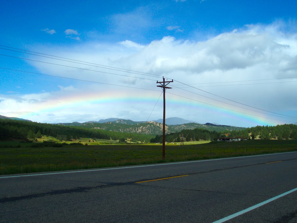 a rainbow in the sky over a road