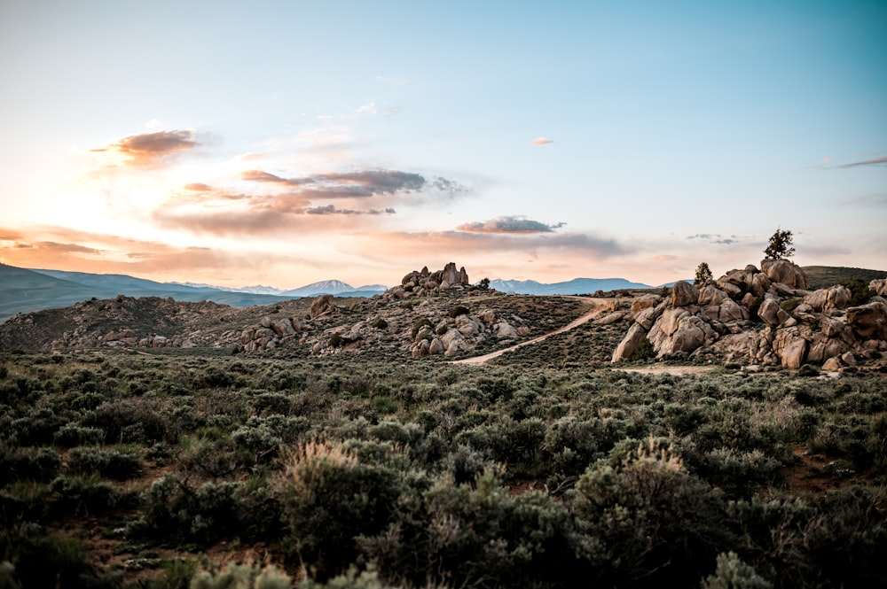 the sun is setting over a rocky landscape