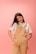 a woman in overalls posing for a picture