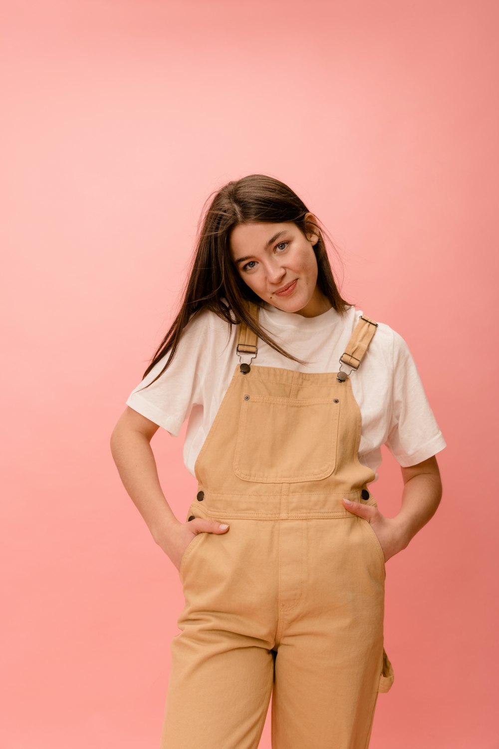 a woman in overalls posing for a picture