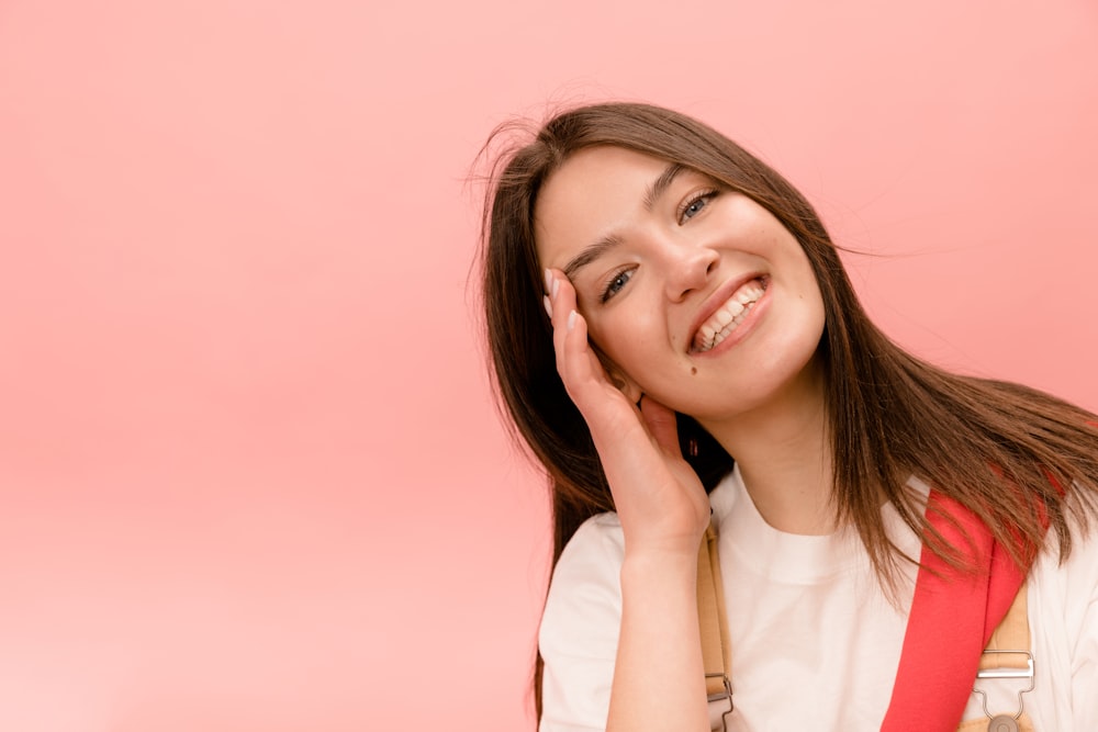 a woman with a red backpack smiles at the camera