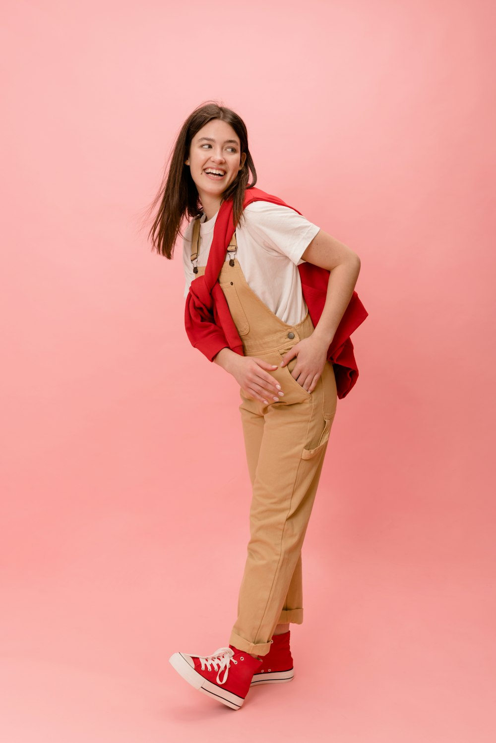 a woman in red and white shirt and tan pants