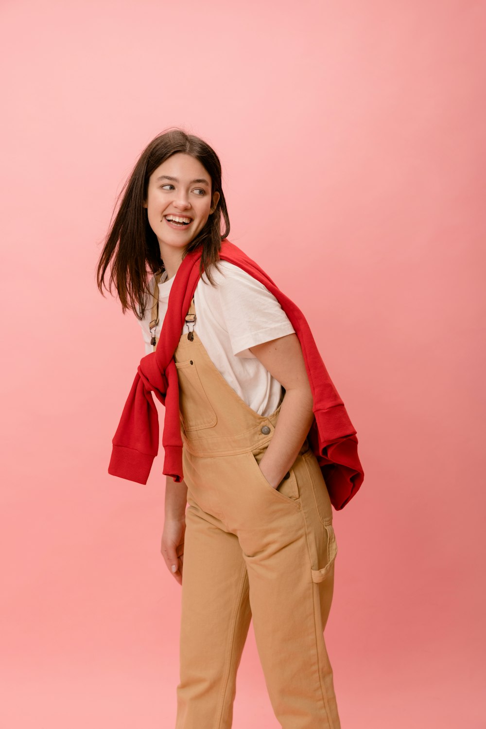 a woman standing in front of a pink background