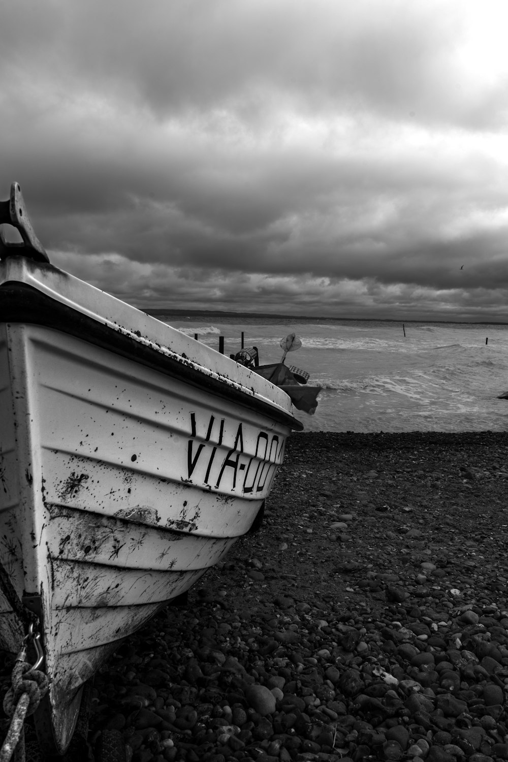 a boat sitting on top of a beach next to the ocean