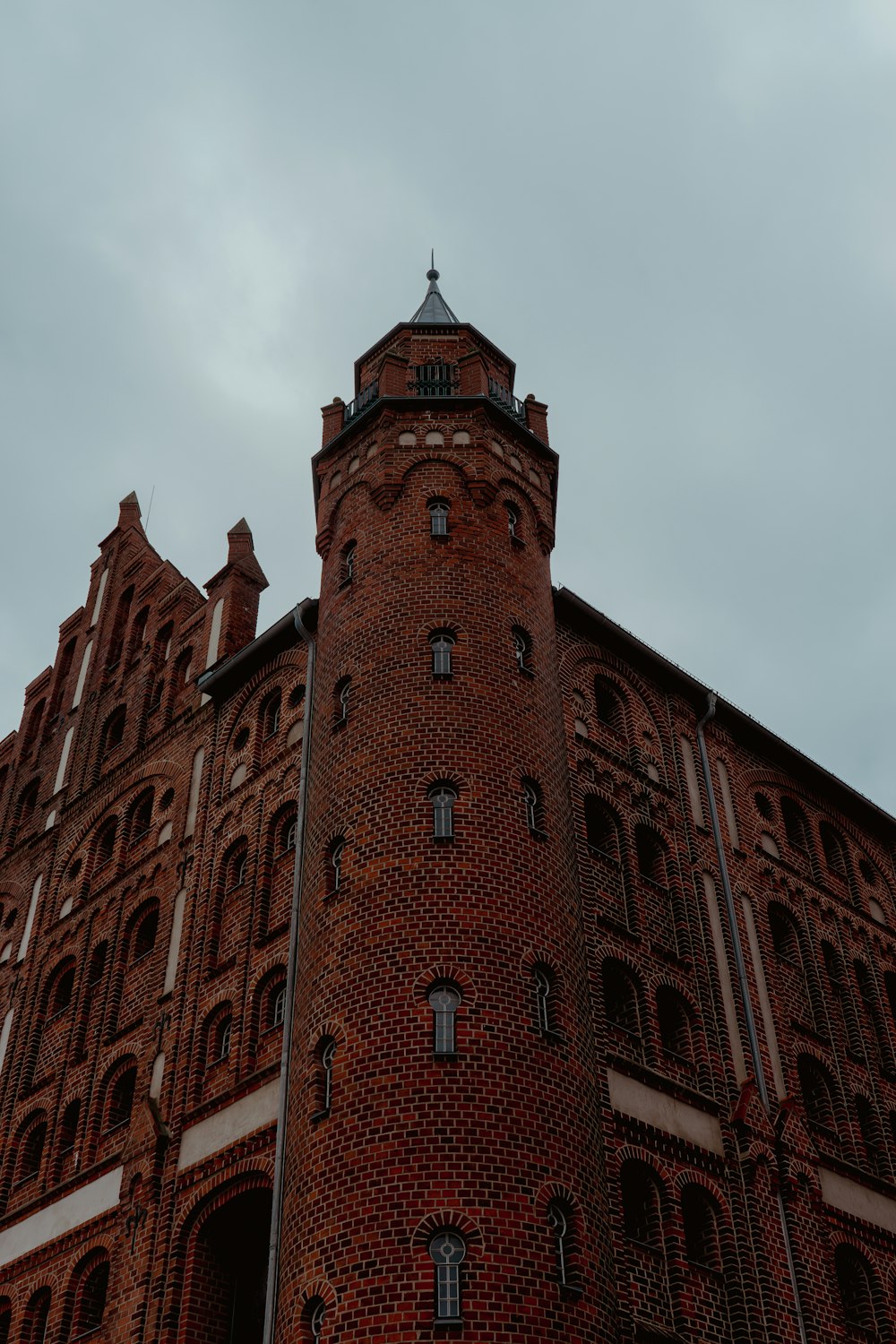 a tall brick building with a clock on the top of it