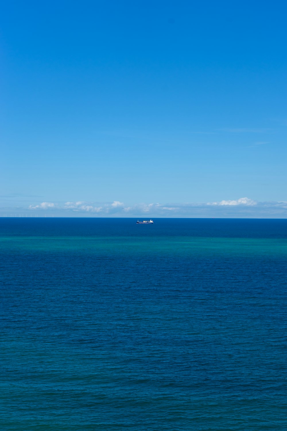 a large body of water with a boat in the distance
