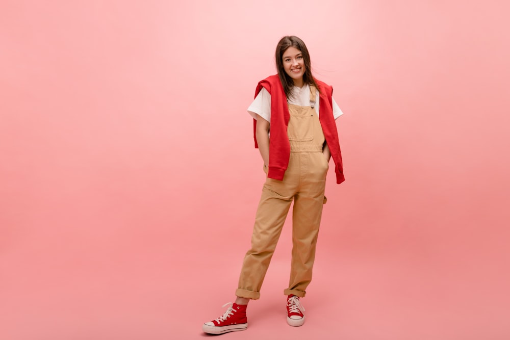 a woman standing in front of a pink background