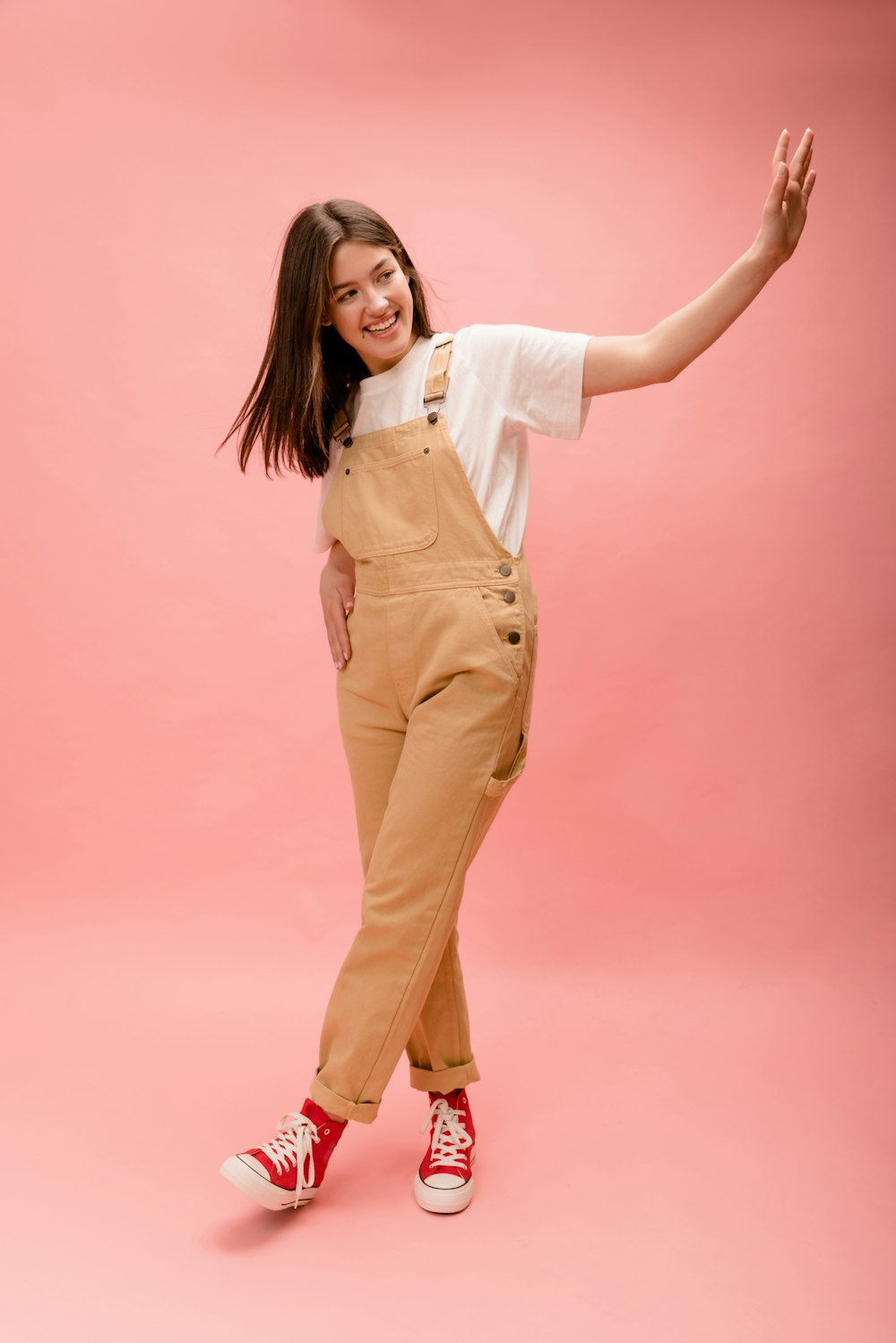 a woman in overalls posing for a picture