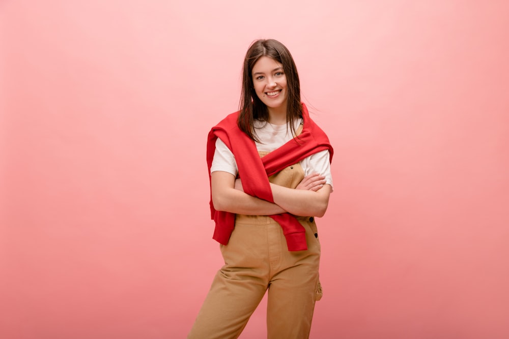 a woman standing with her arms crossed wearing a red scarf