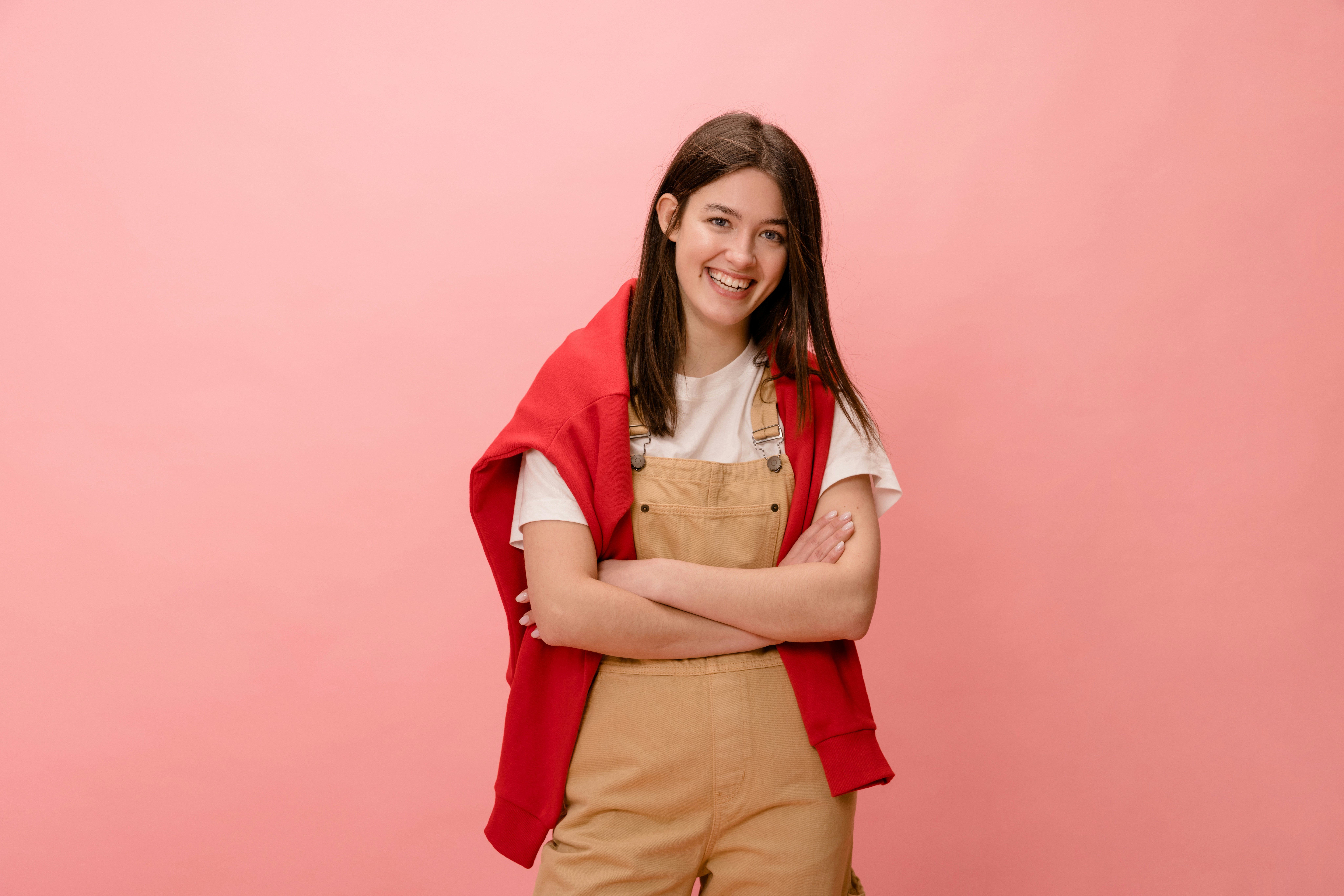a woman standing in front of a pink wall
