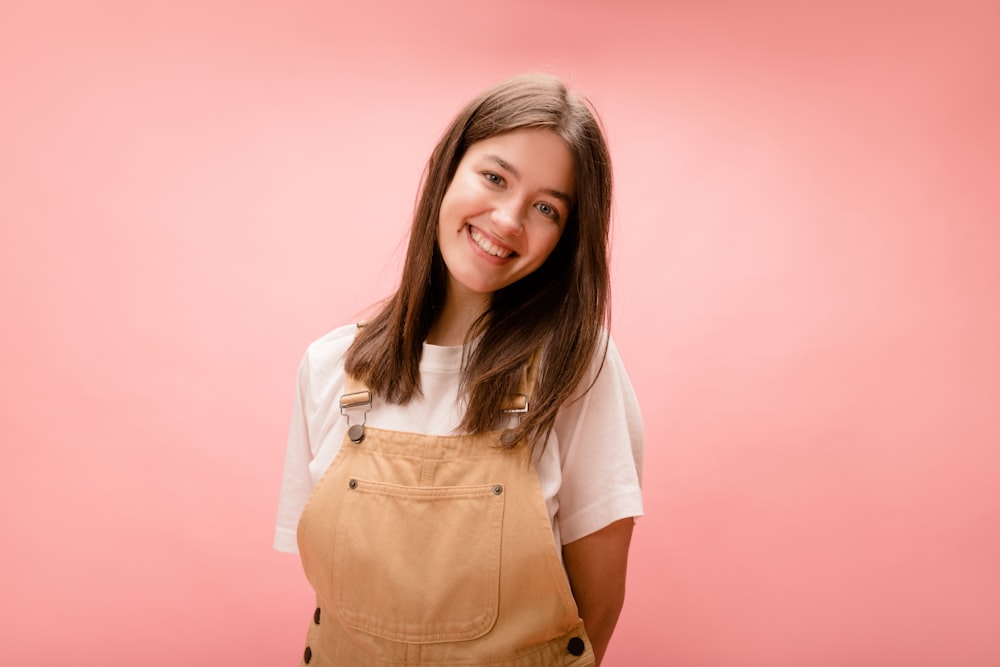 a woman in overalls posing for a picture