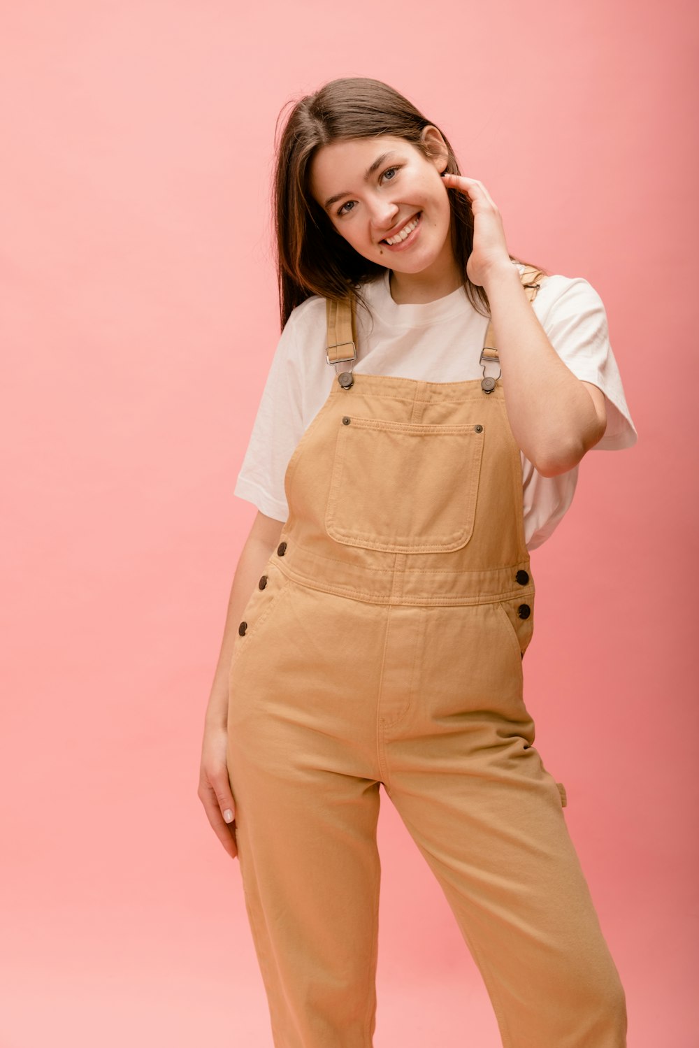 a woman in overalls posing for a picture