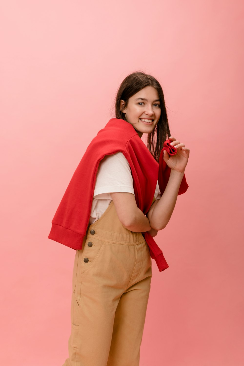 a woman wearing a red scarf and tan pants