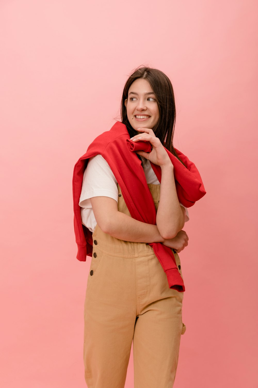 a woman standing with her arms crossed wearing a red scarf