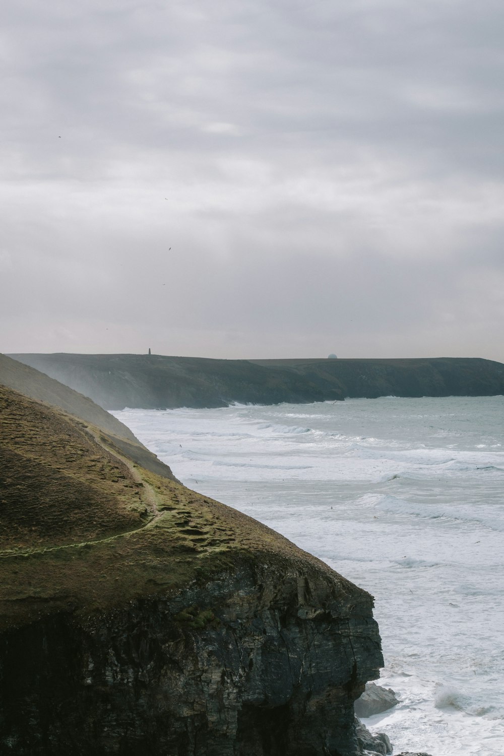 a person standing on the edge of a cliff overlooking the ocean