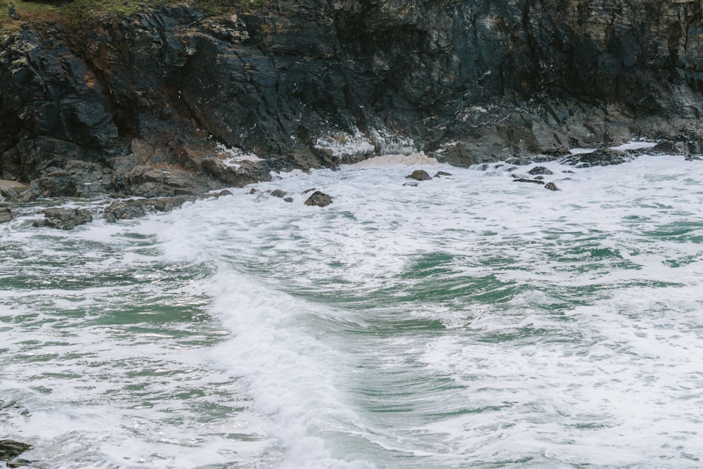 a large body of water next to a rocky cliff