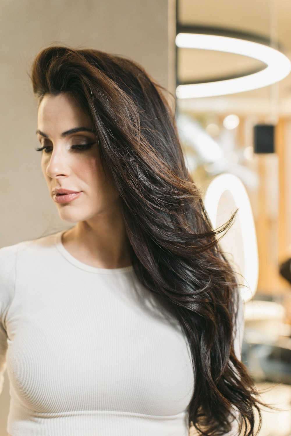 a woman in a white top is holding a cell phone