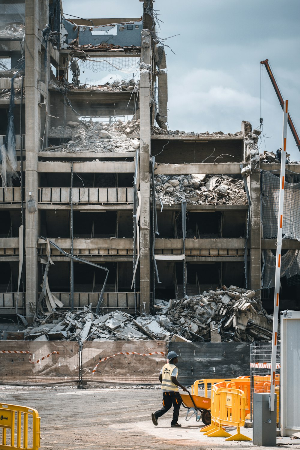 a construction worker walks past a demolished building