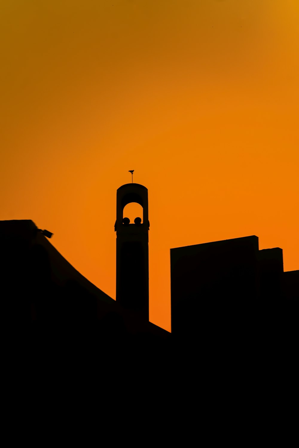 a silhouette of a building with a bell tower