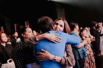 two women hugging each other in front of a crowd of people