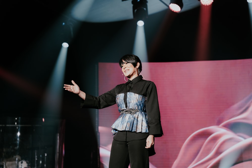 a woman standing on a stage with a microphone