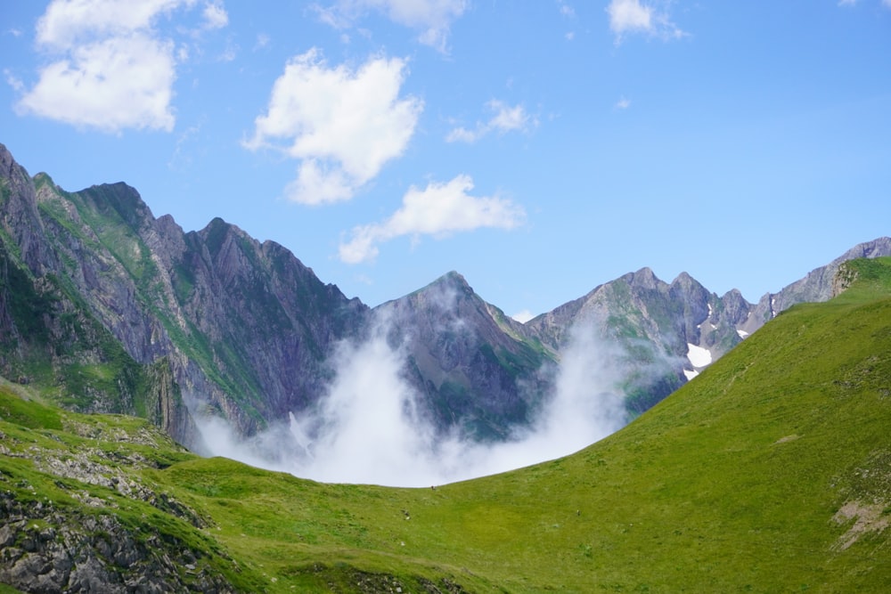 a grassy valley with mountains in the background