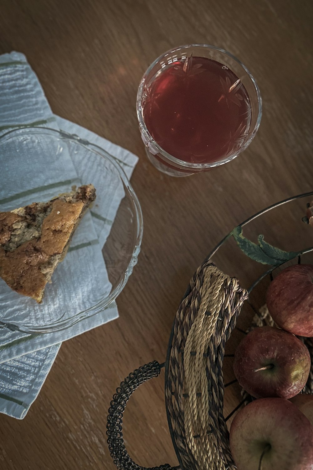 a basket of apples next to a glass of tea